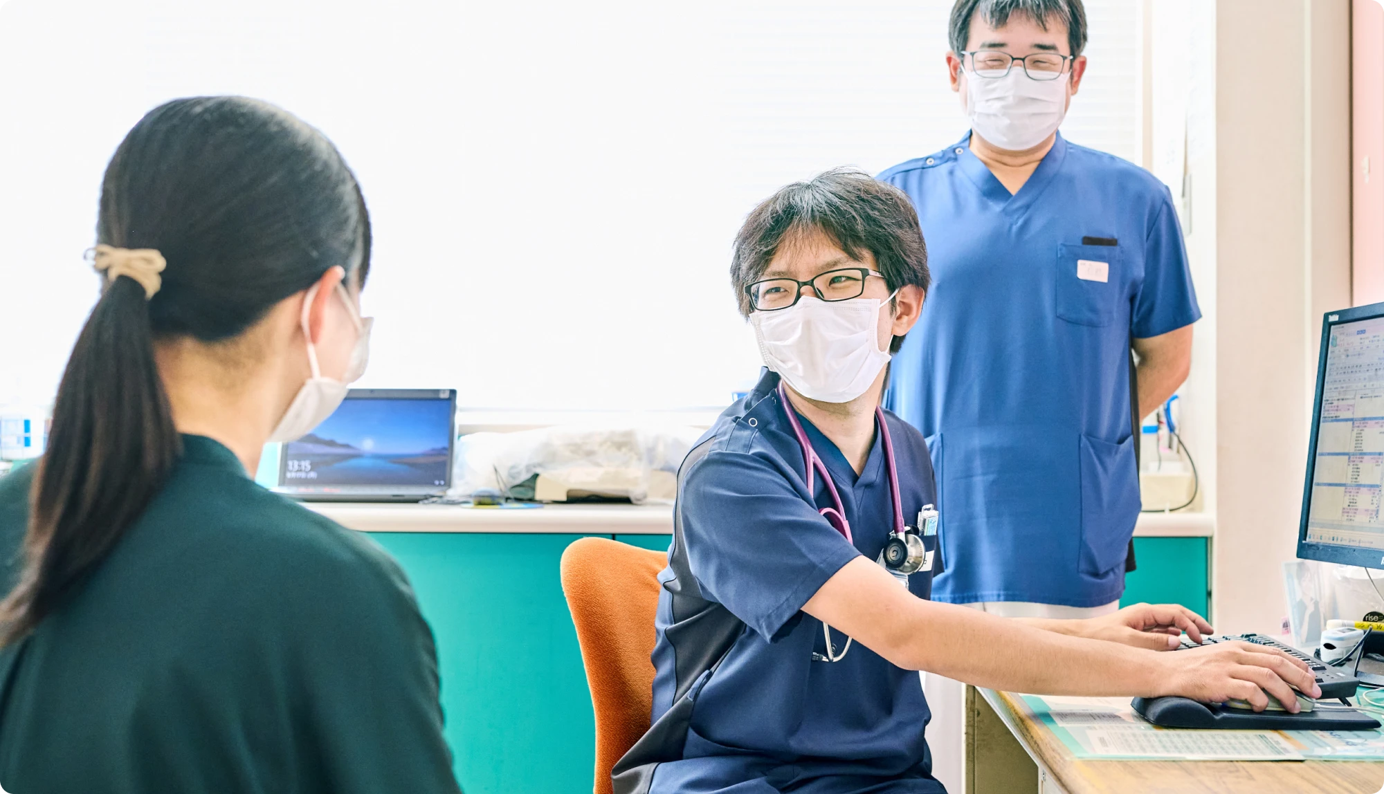 診察室で電子カルテを操作する医師